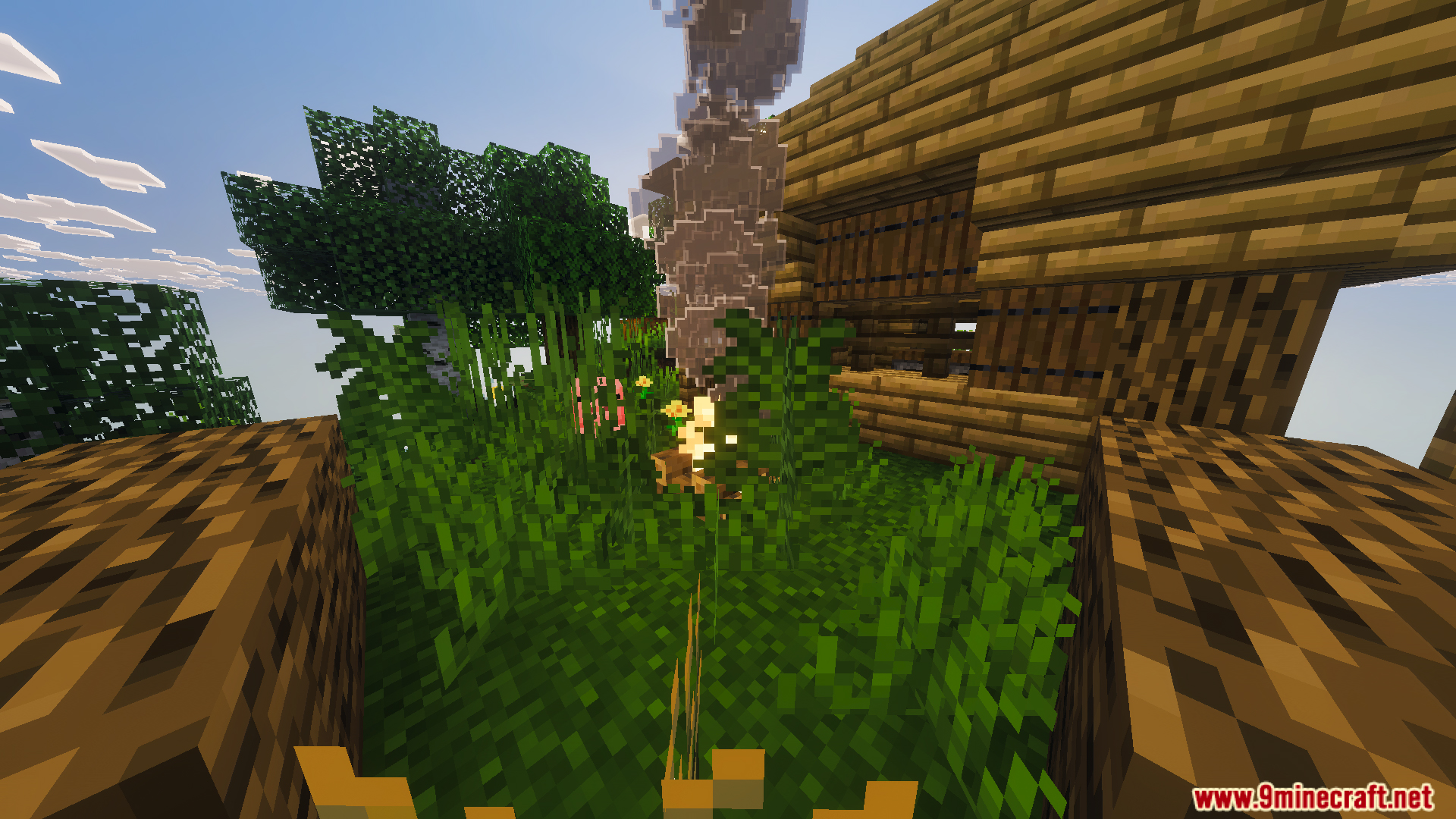 Grassy area with a campfire and a wooden house in the sky
