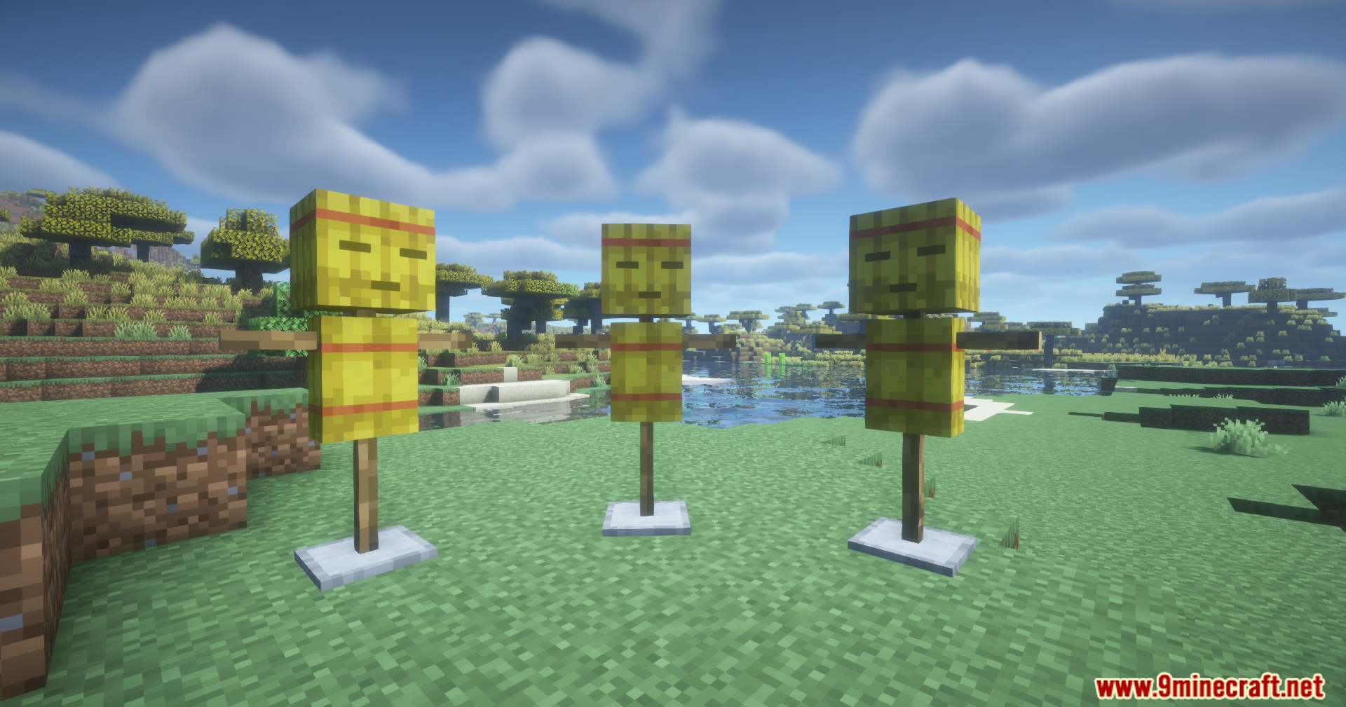 Three straw training dummies standing on a grassy field in Minecraft