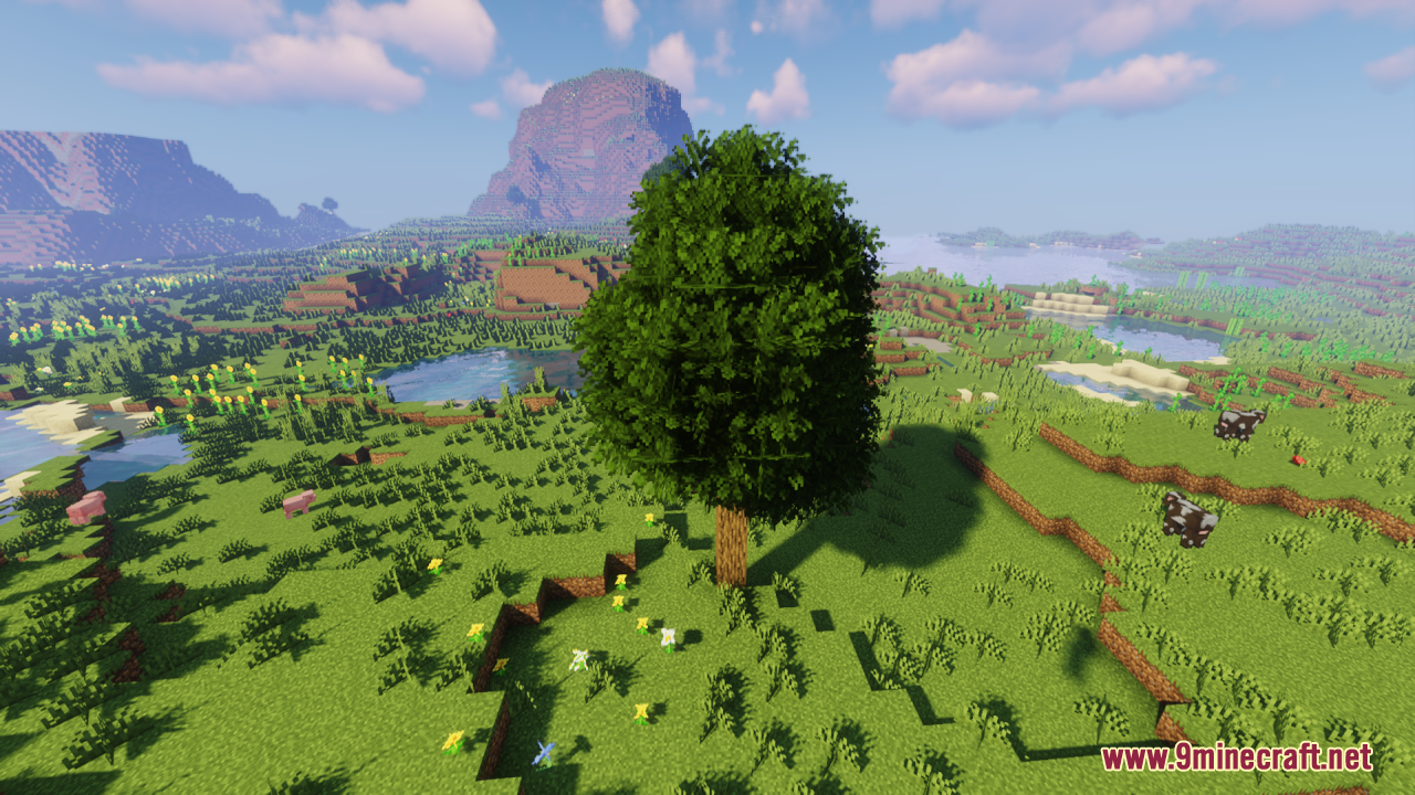 Rainbow's Foliage Resource Pack Screenshot 4 A tall bushy tree stands on a hill with mountains in the background