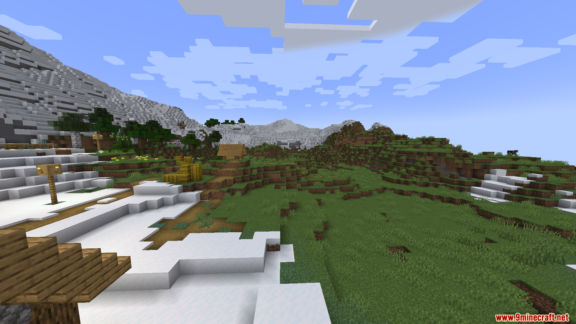 Random Optimization Mod Screenshot 9 A snowy village landscape with hay bales and mountains in the distance
