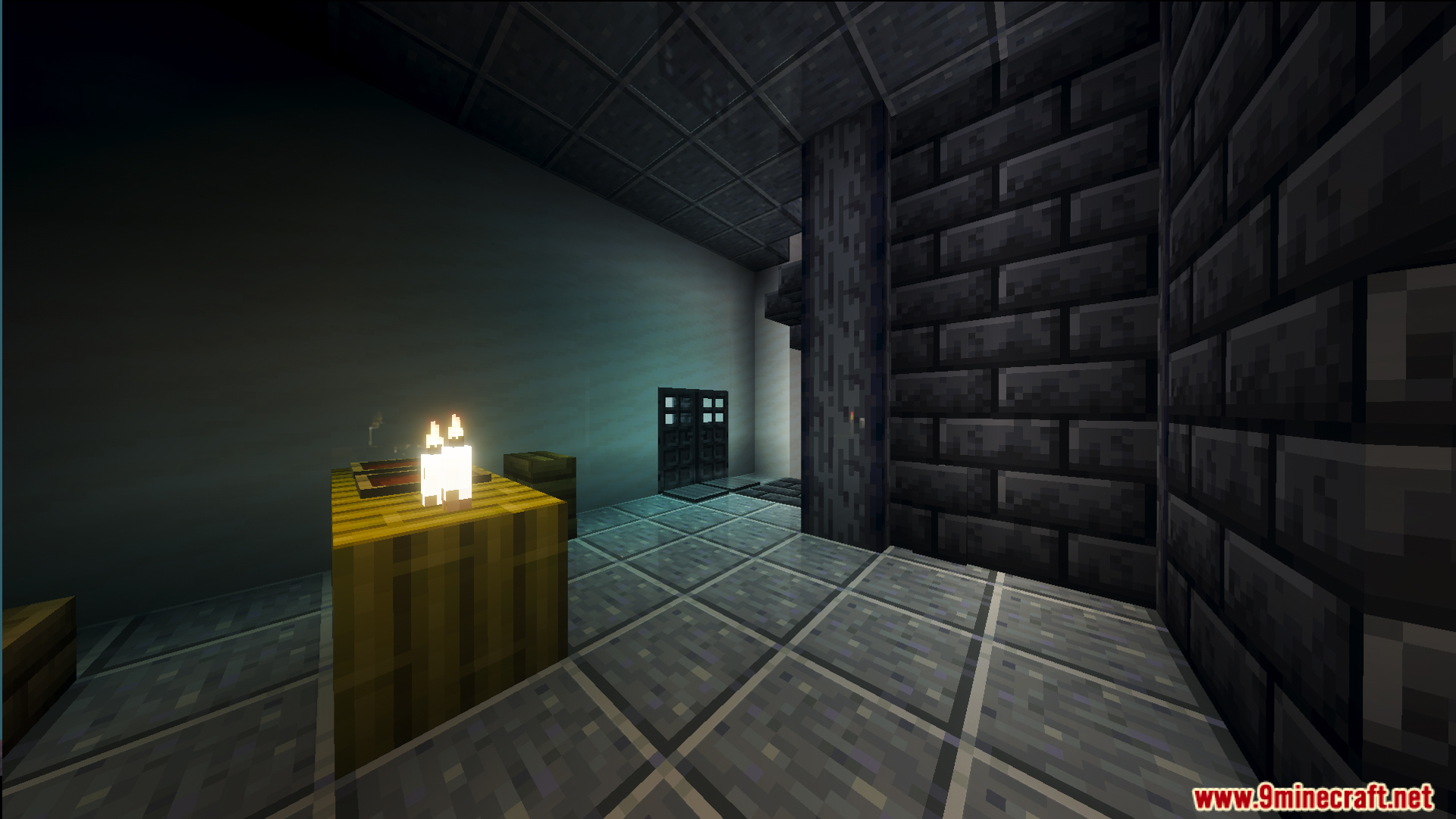 Dimly lit room with candles on a table and dark stone walls