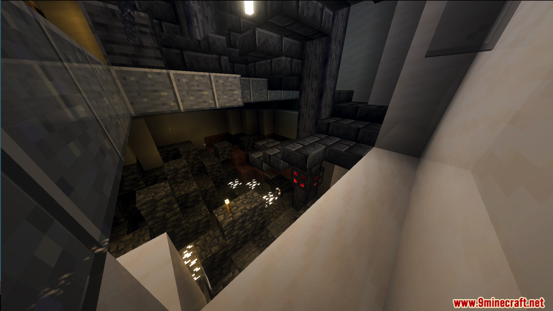 A dark cave dungeon with stone structures and glowing lights viewed from above