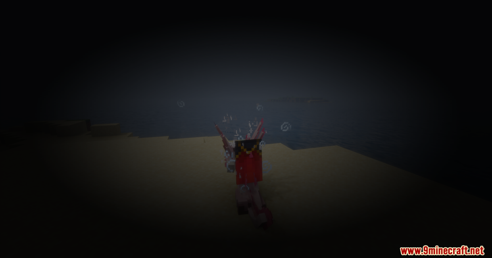 A player with a red cape stands on a dark beach with particles