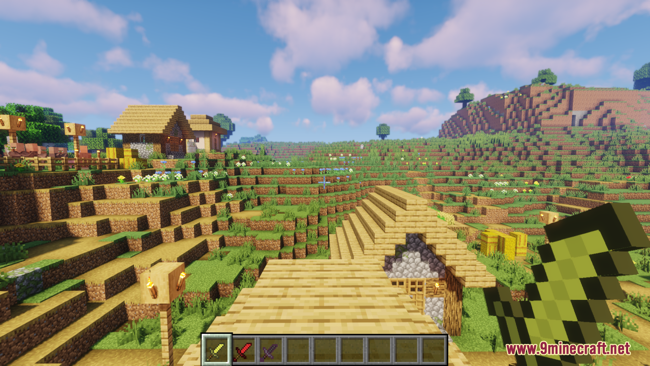 Player holds a short green sword while looking at a village on hills