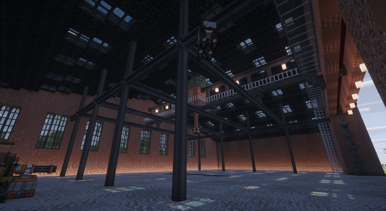 Interior view of a brick hangar showing industrial steel beams and skylights