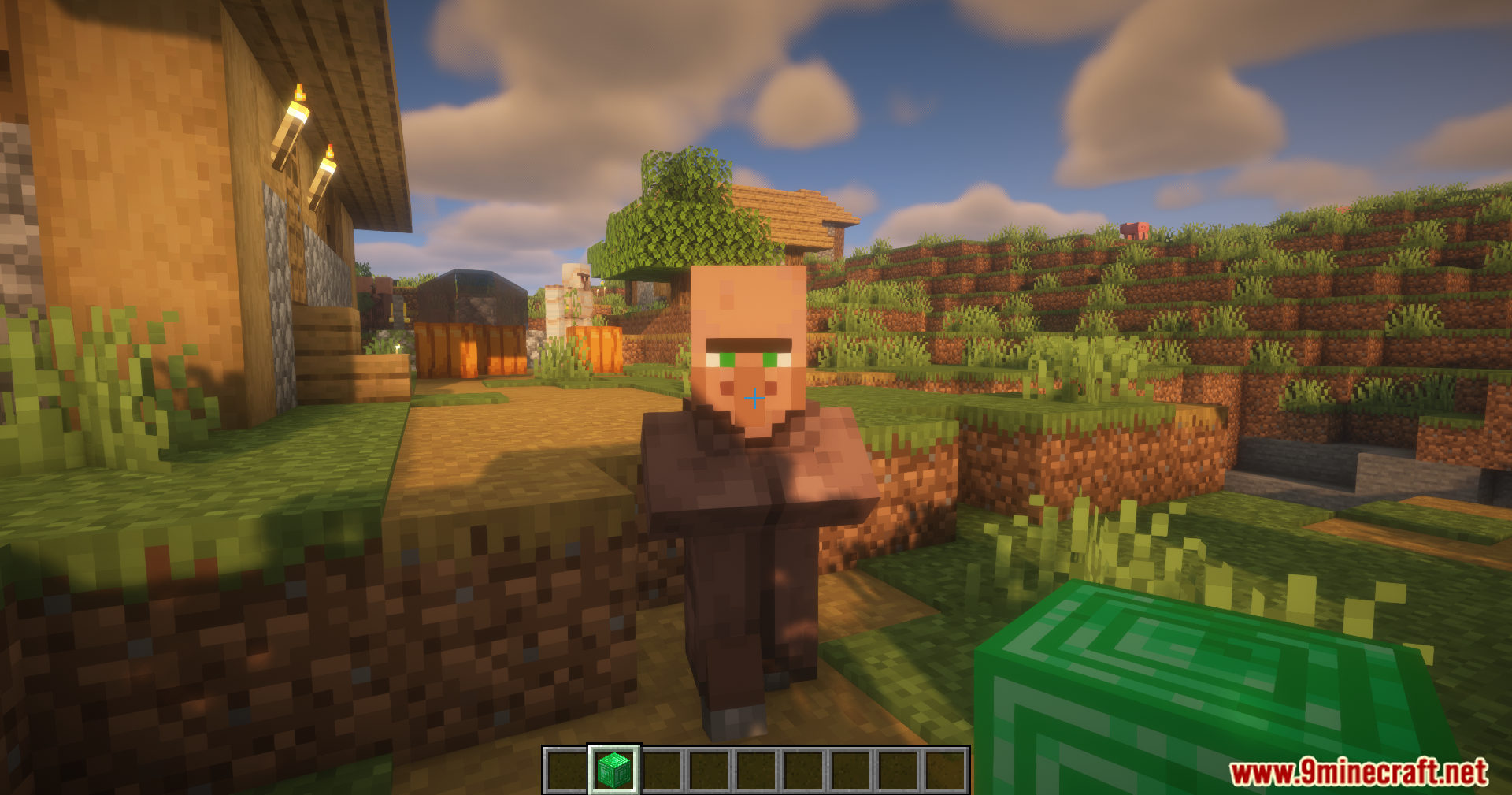 Simple Villager Follow Mod Screenshot 3 A villager watches a player holding an emerald block in a sunny village
