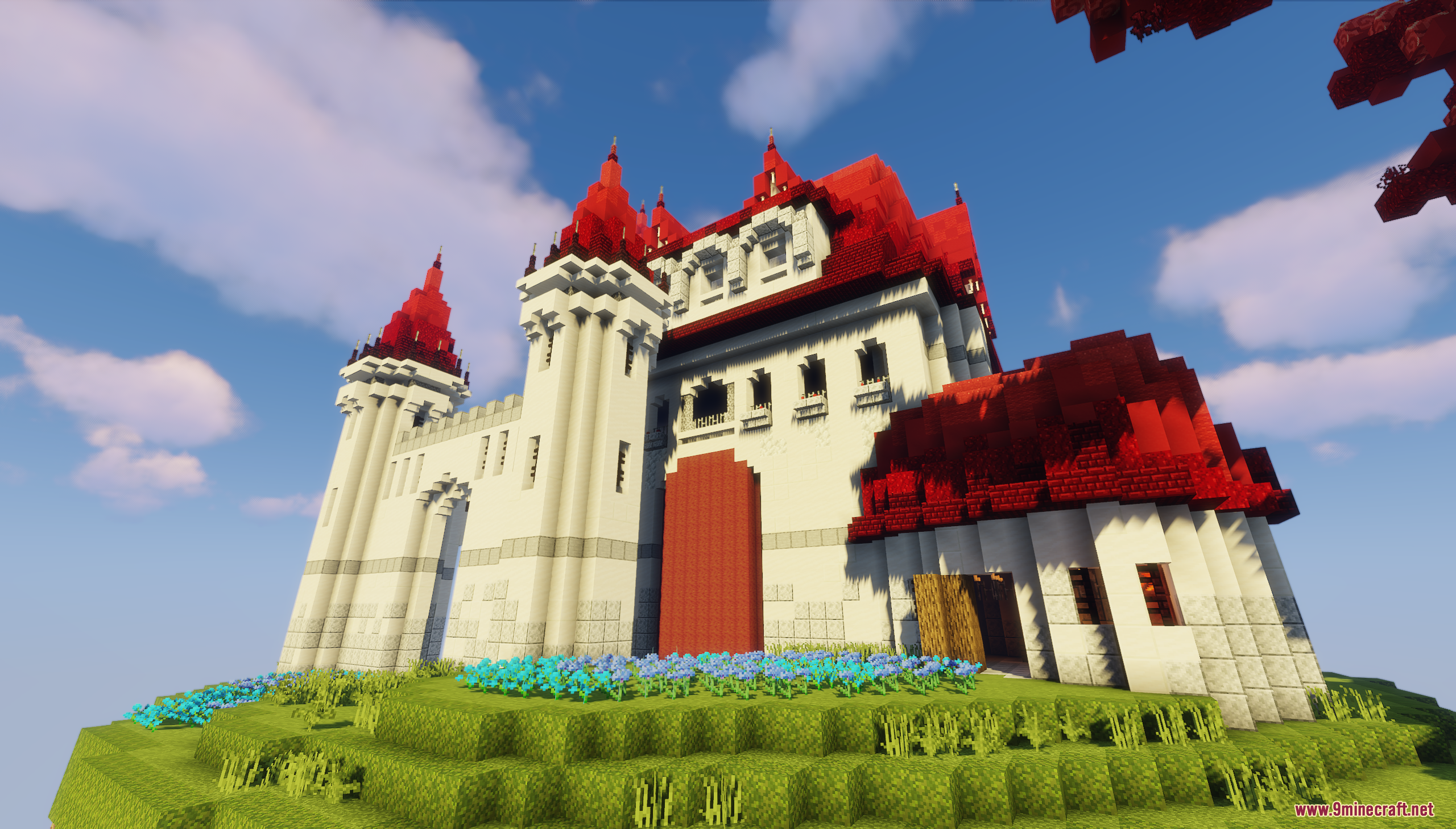 A detailed view of the white castle with vibrant red roofs and flowers
