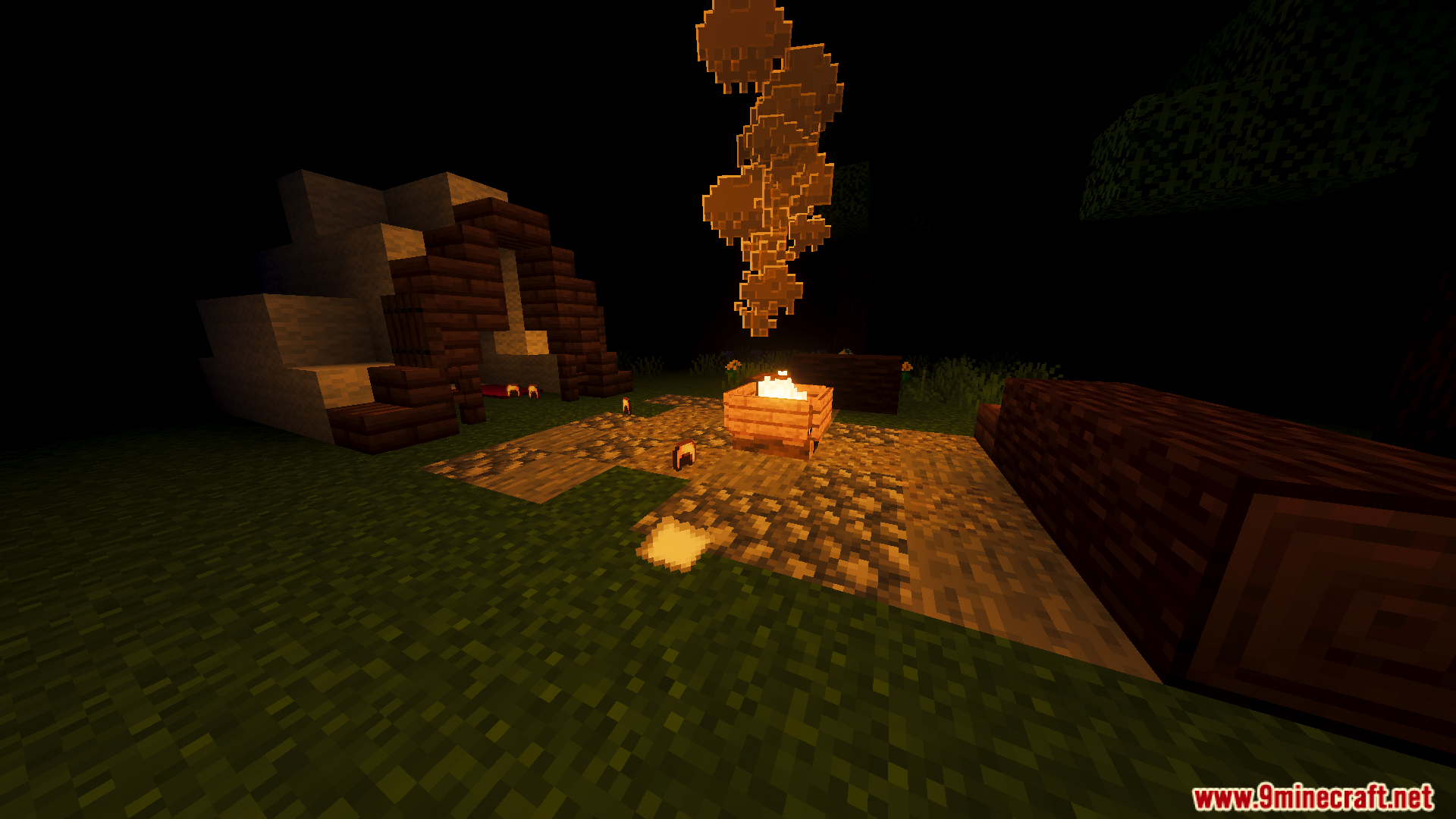A lit campfire with smoke next to a small wooden shelter structure