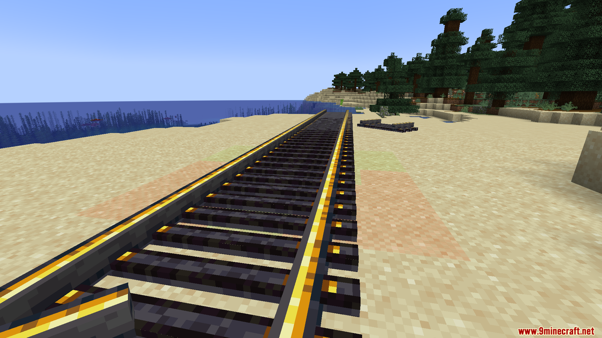 Steam N Rails Neoforge Mod Screenshot 7 Wide railway tracks with golden rails stretching across a sandy beach near water