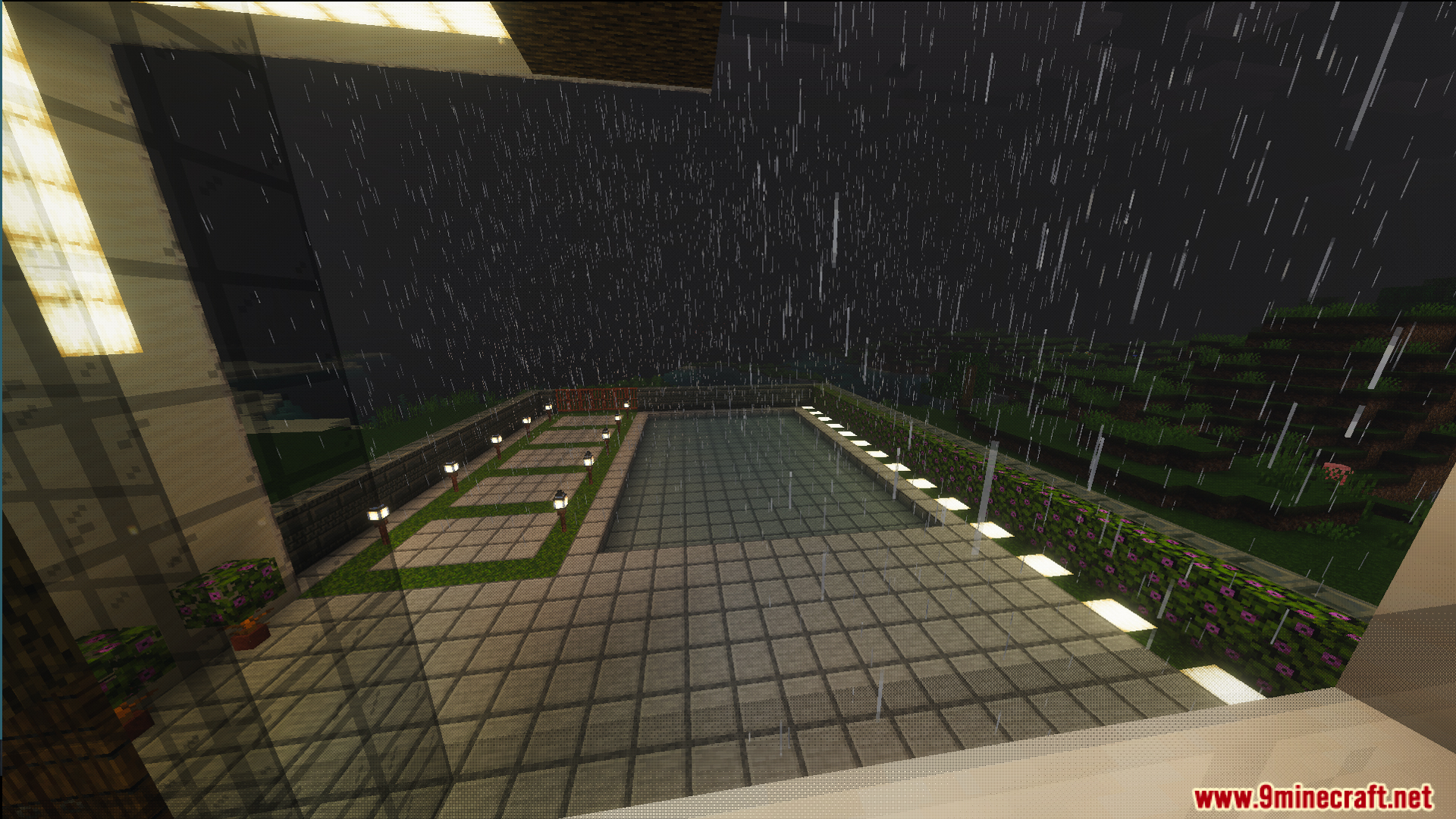 Outdoor swimming pool and garden area seen through a window at night