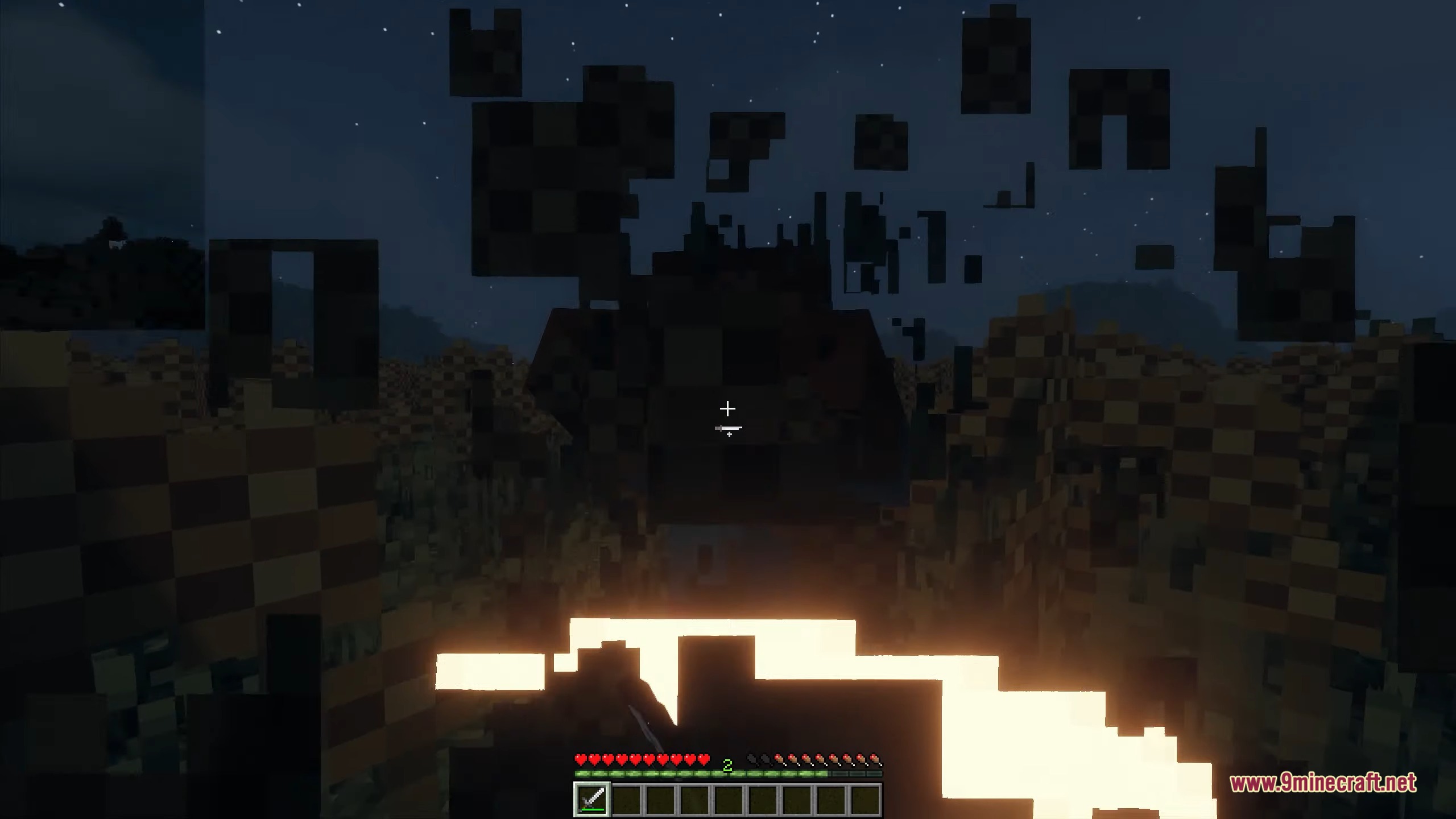 A player swings a sword through tall grass at night with glowing effects