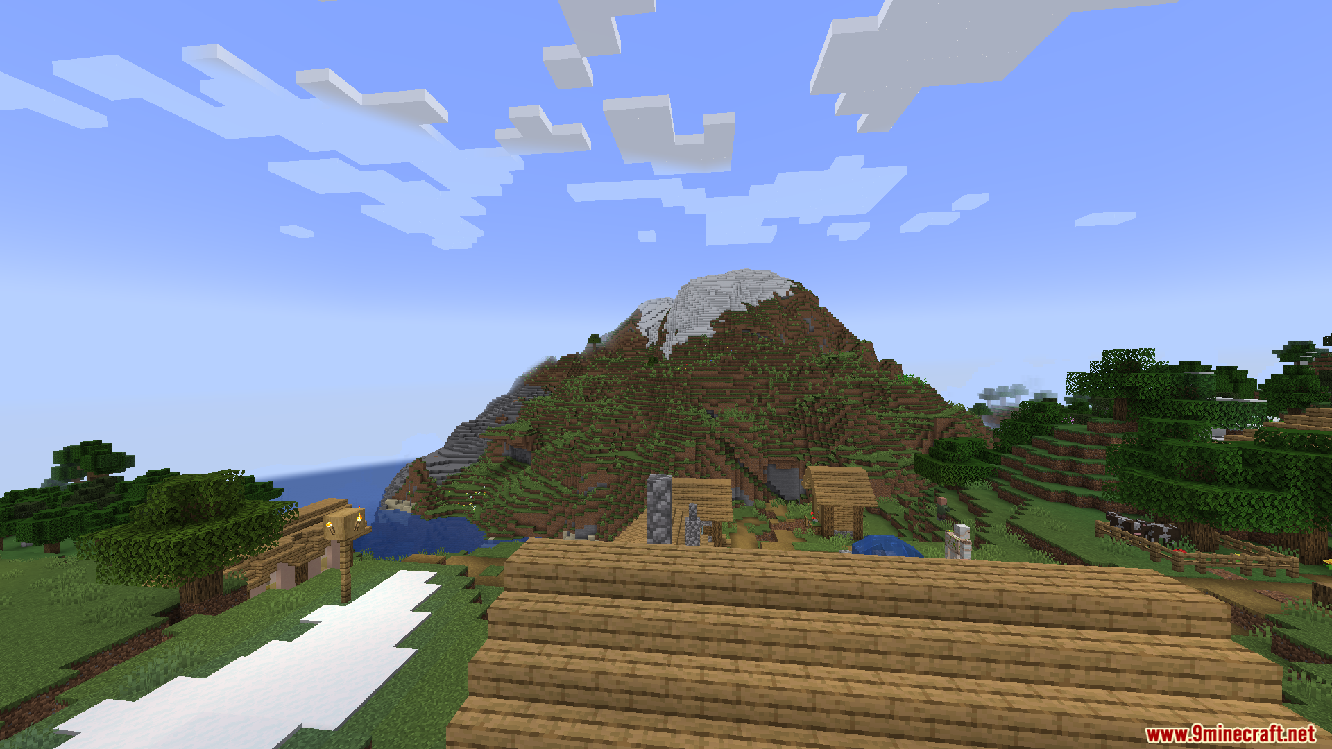 Thaumon PT BR Translation Resource Pack Screenshot 10 A scenic view of a mountain and village houses from a wooden rooftop