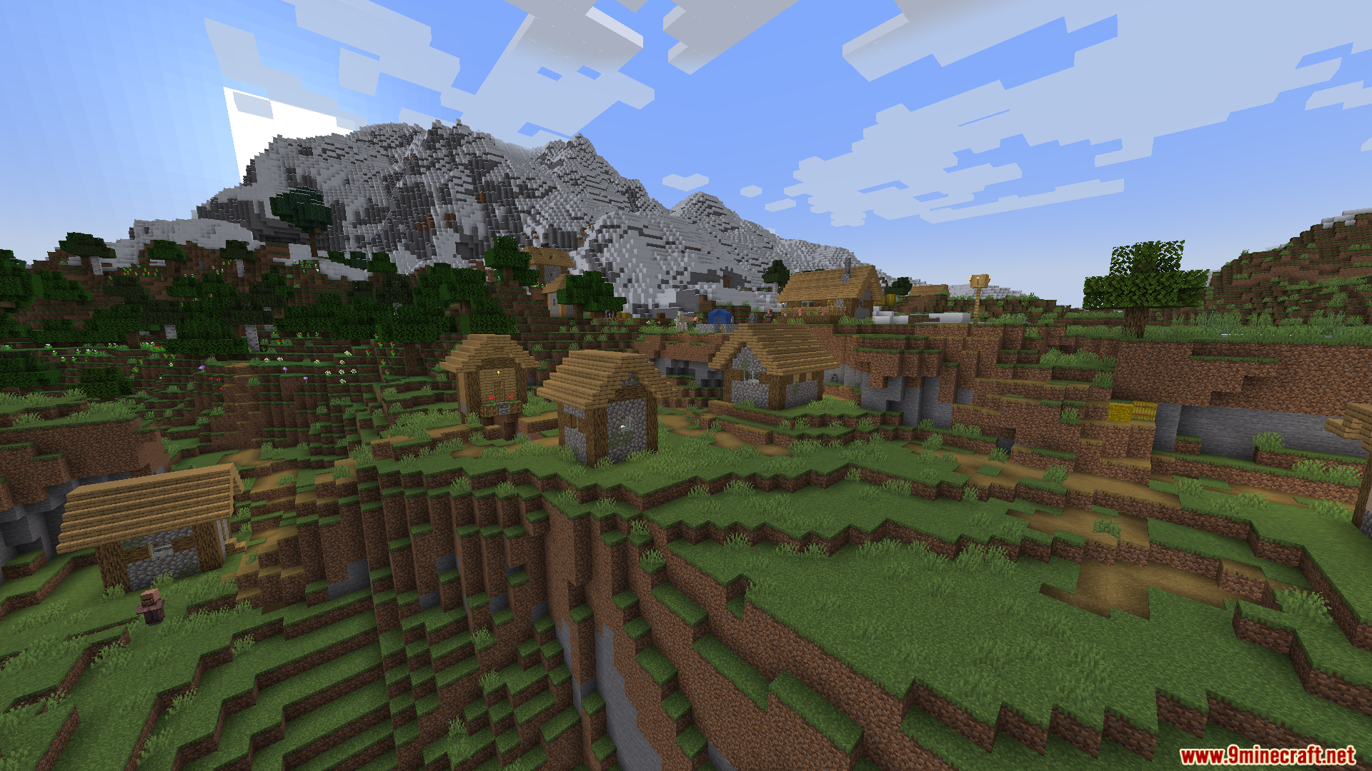 Thaumon PT BR Translation Resource Pack Screenshot 5 A wide view of a Minecraft village nestled in a valley with mountains