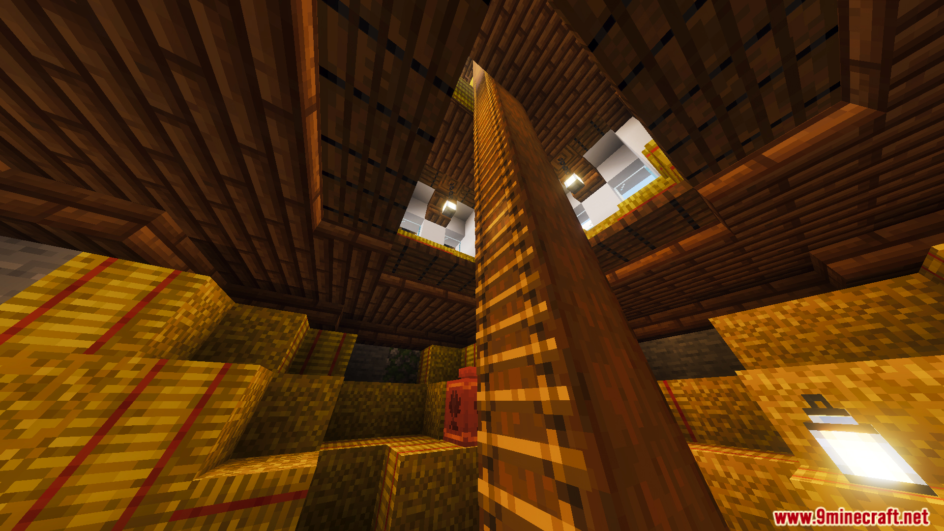 Inside a barn with stacked hay bales and a tall wooden ladder