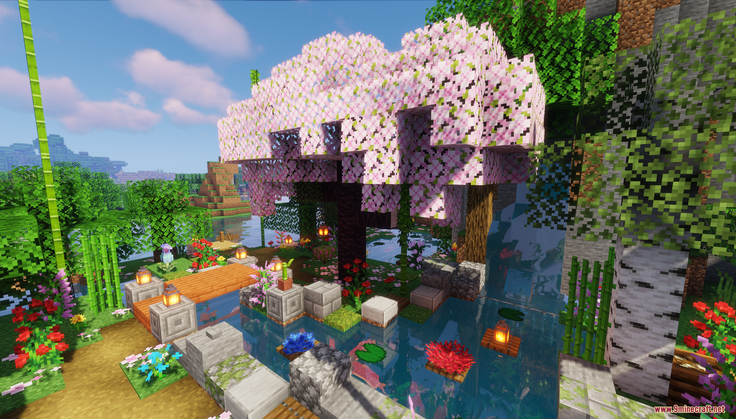 A large pink cherry blossom tree stands beside a peaceful garden pond