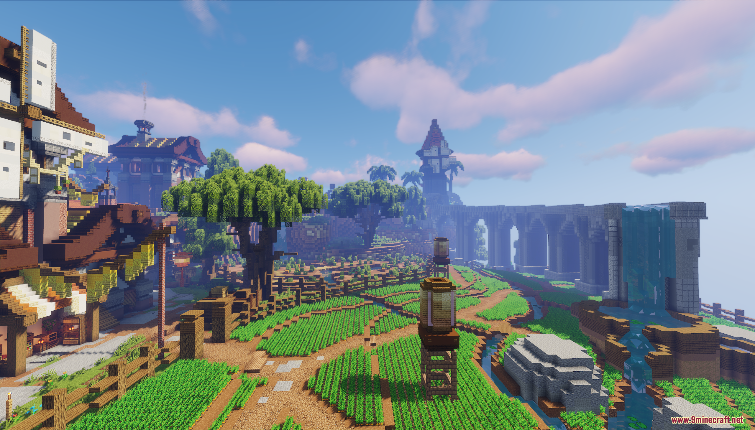 Lush green fields and a stone waterfall near a large bridge