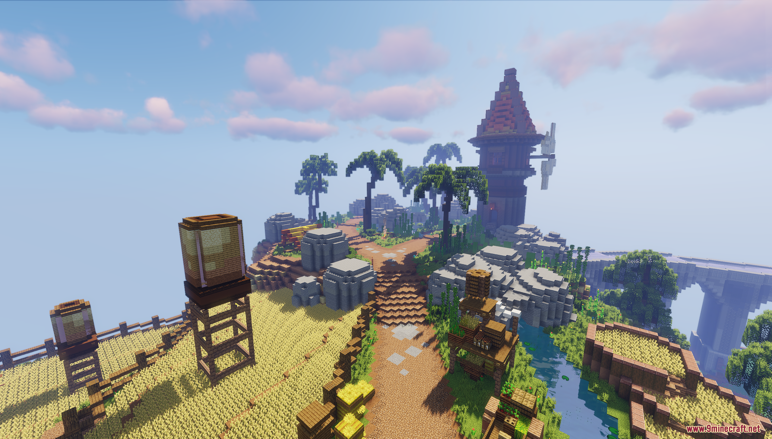 A dirt path leads through a farm with a windmill and water towers