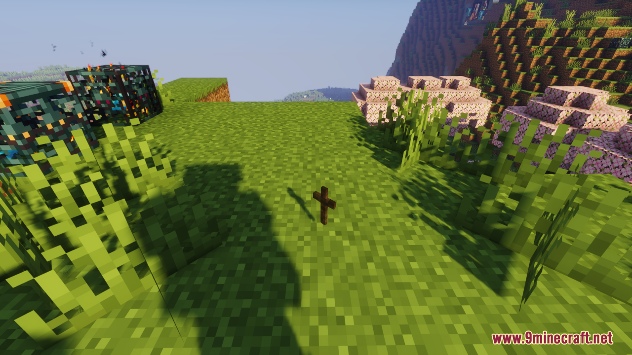 Wood Totem Cross Resource Pack Screenshot 8 A wooden cross totem item sits on the grass in a sunny landscape