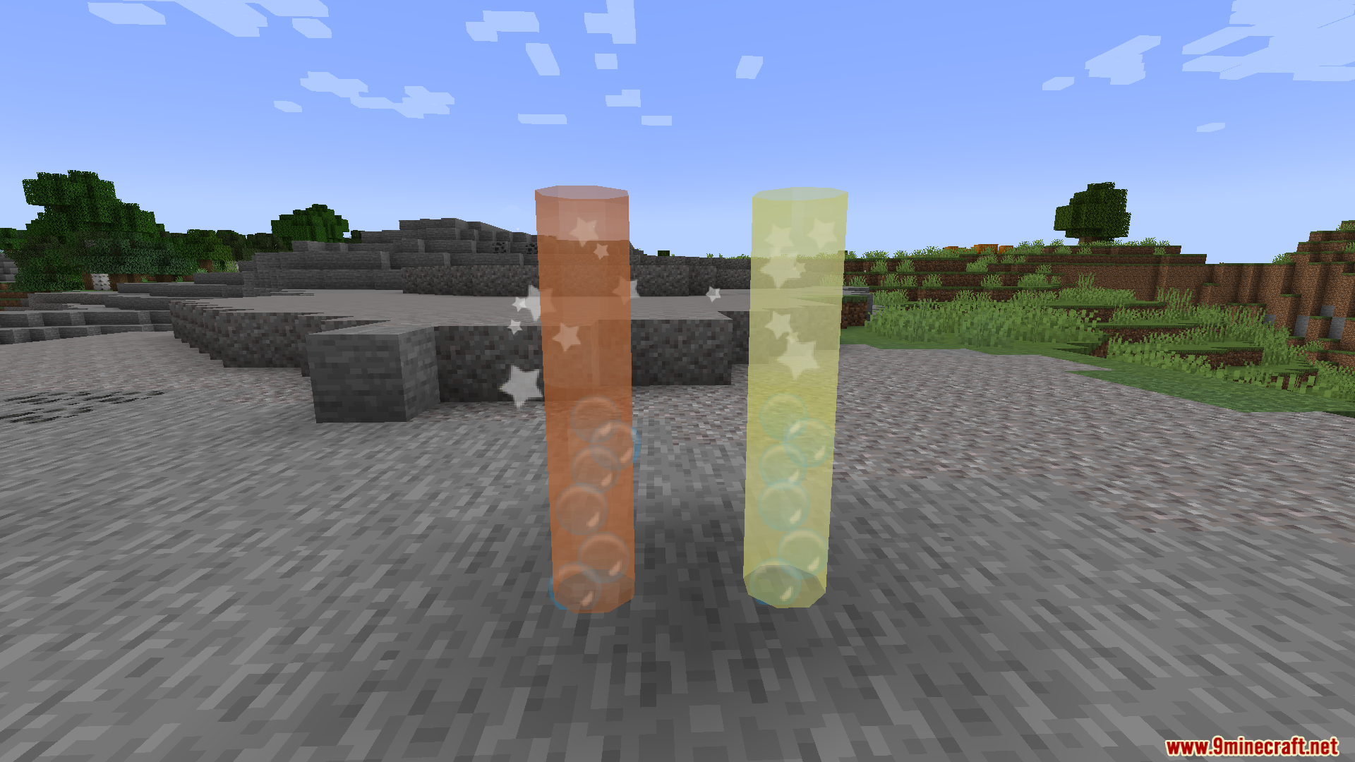 Orange and yellow glass cylinders displaying floating bubbles and sparkling stars