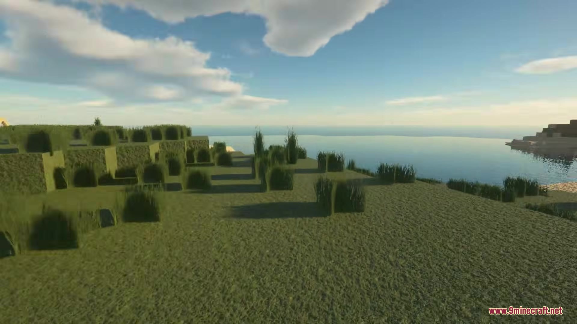 A BTV Texture Pack 64px Full 3 D POM Resource Pack Screenshot 4 Lush green grass field overlooking a calm body of water under sunlight