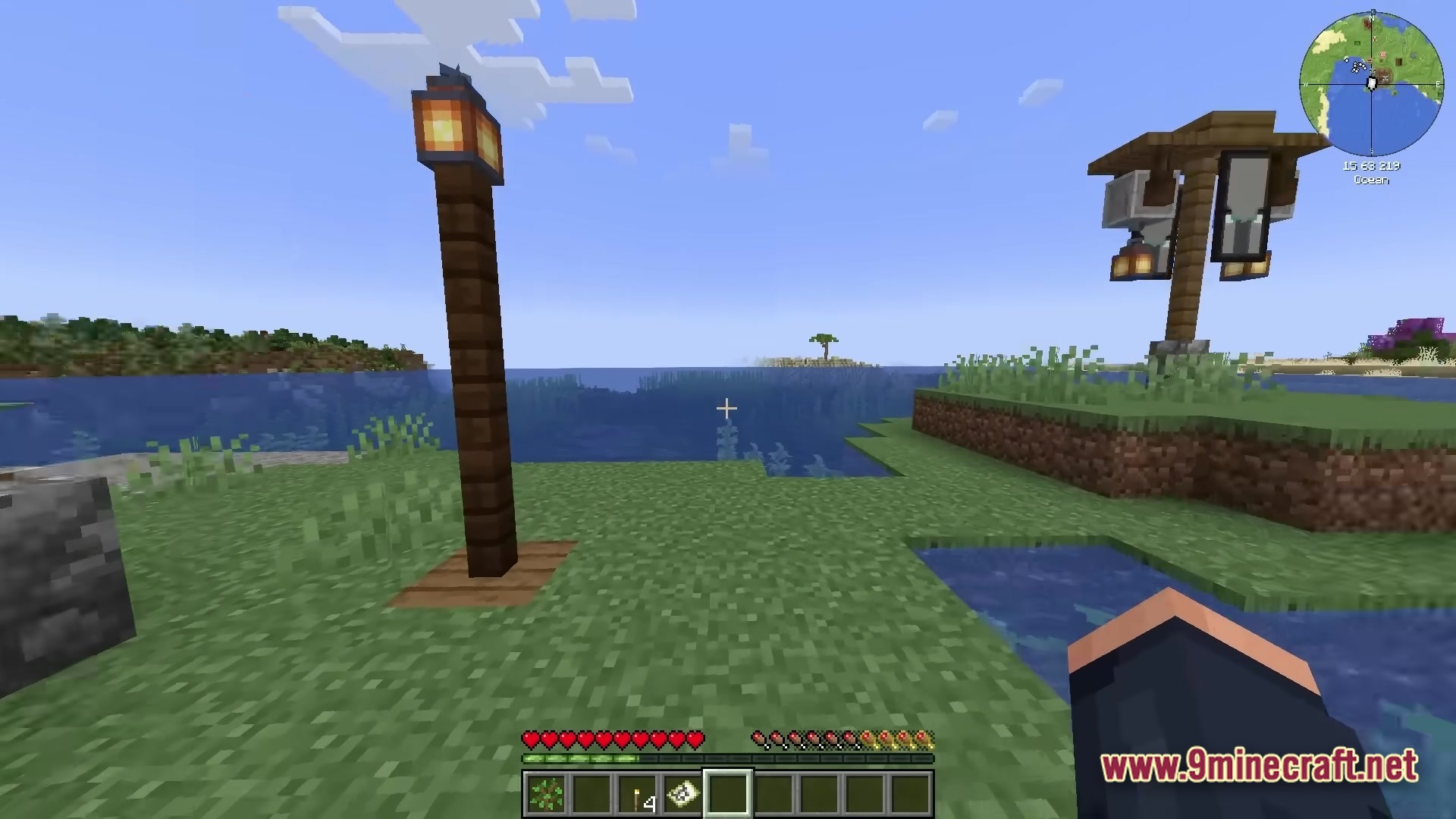 All The Mods 10 ATM10 Modpack Screenshot 2 A coastal Minecraft landscape featuring decorative lamp posts and an ominous Illager banner near the ocean