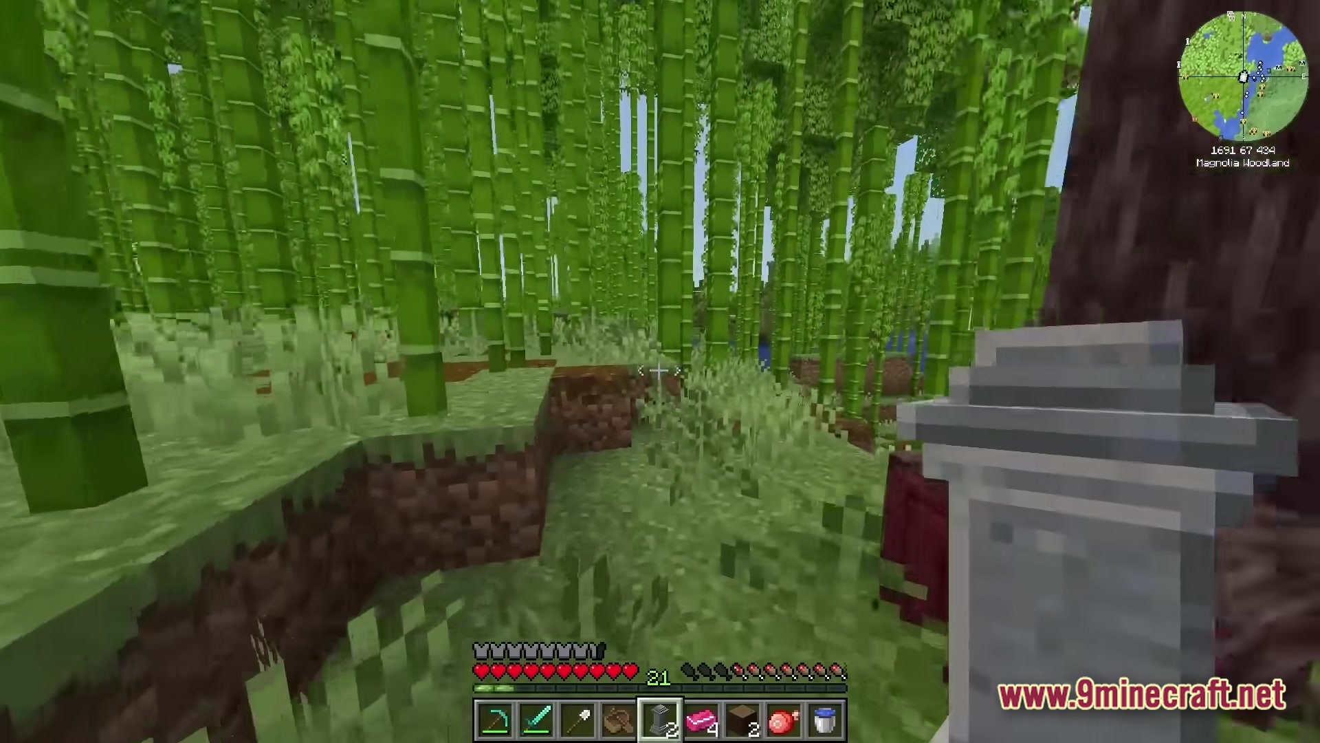 A player explores a dense bamboo forest biome while holding a decorative stone grave marker