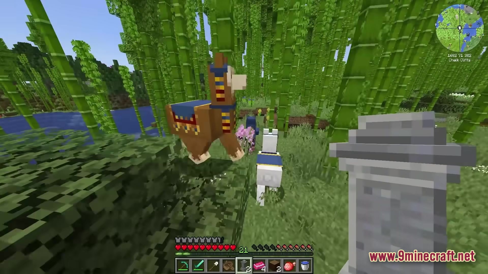 A Wandering Trader with two llamas stands in a bamboo forest near a stone waystone