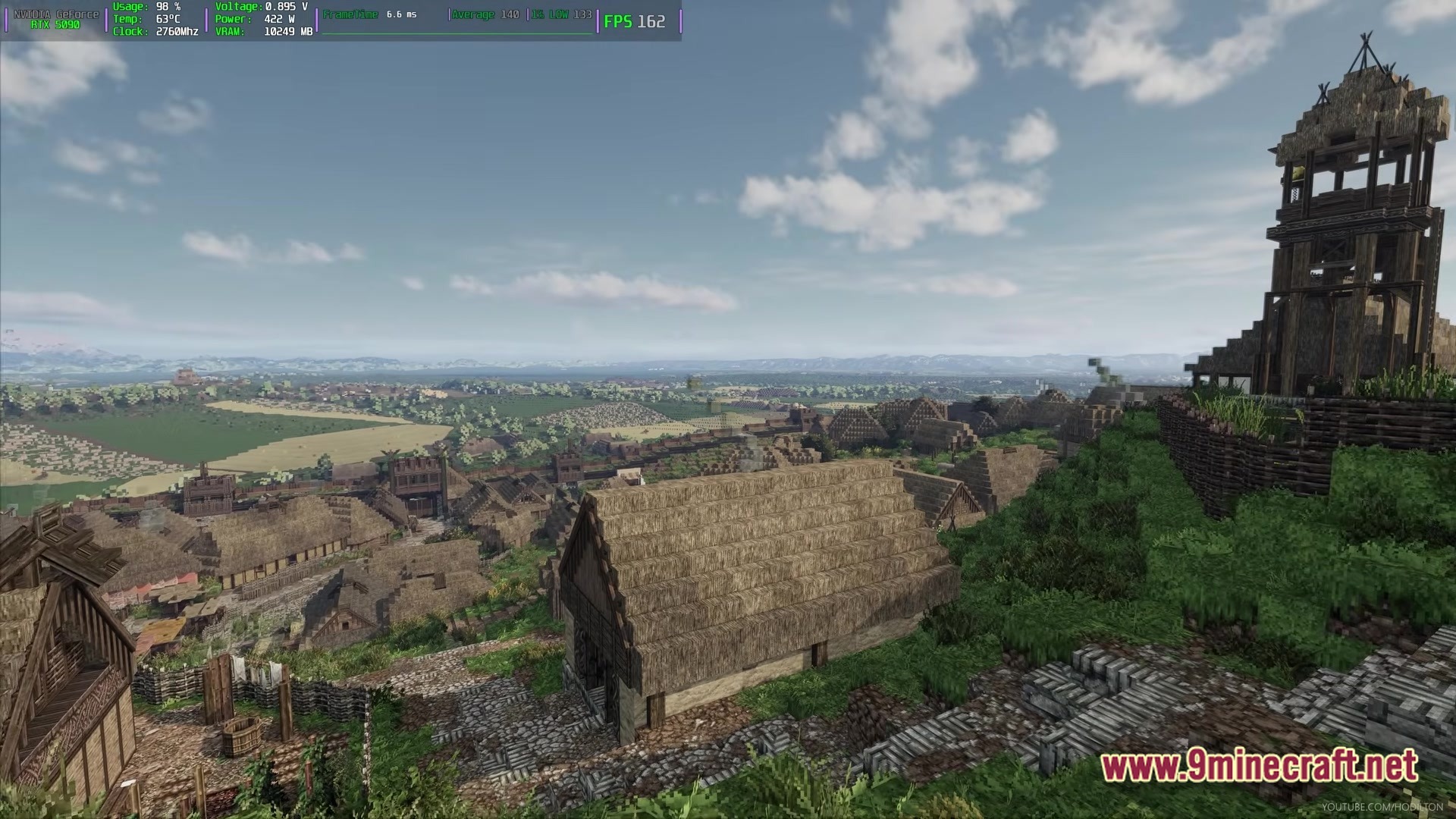 Arda Craft Modpack Screenshot 2 A sprawling medieval settlement with thatched-roof houses and a wooden watchtower overlooking a vast valley