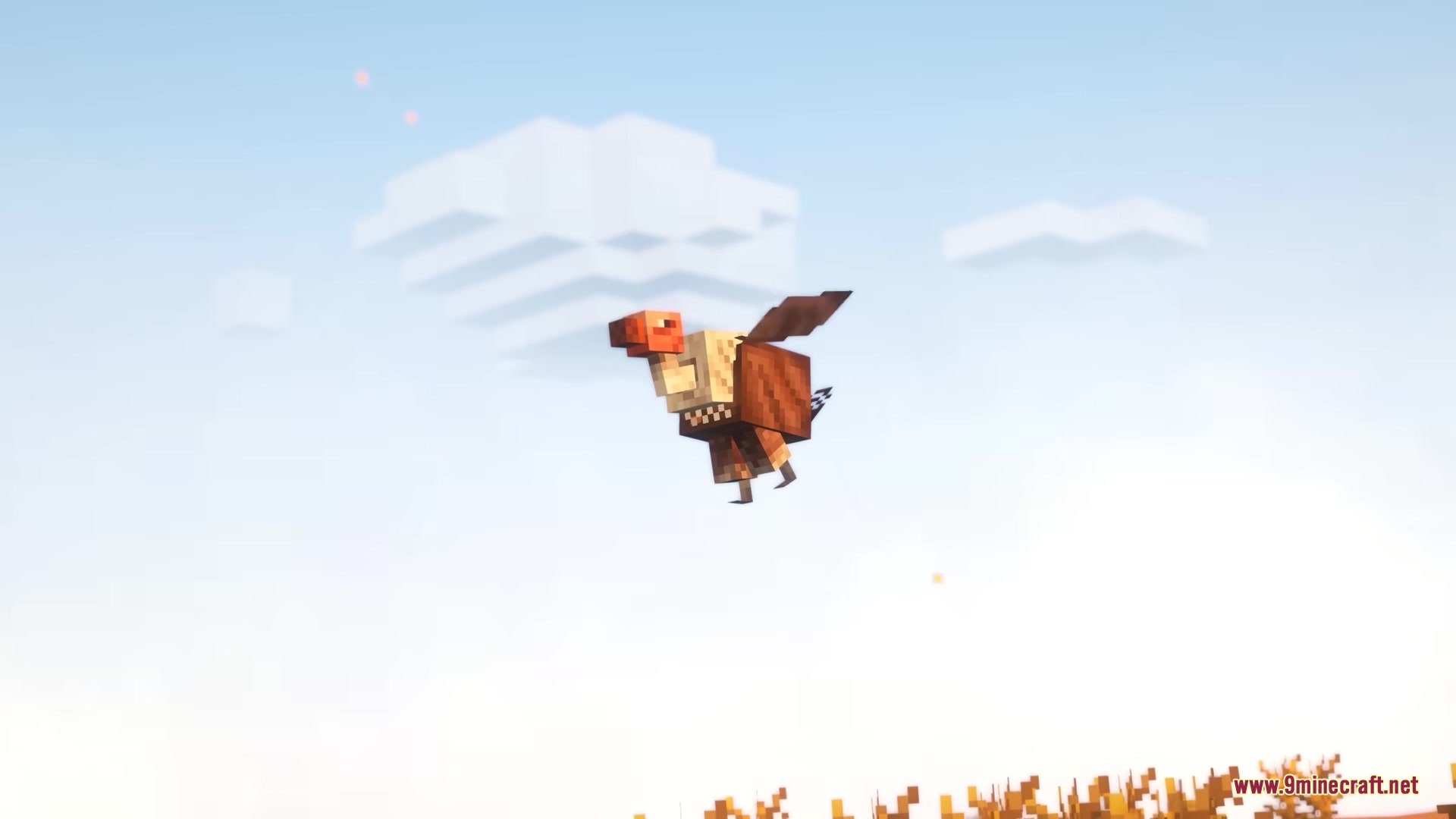 A vulture with brown feathers and a red head flies through the clouds