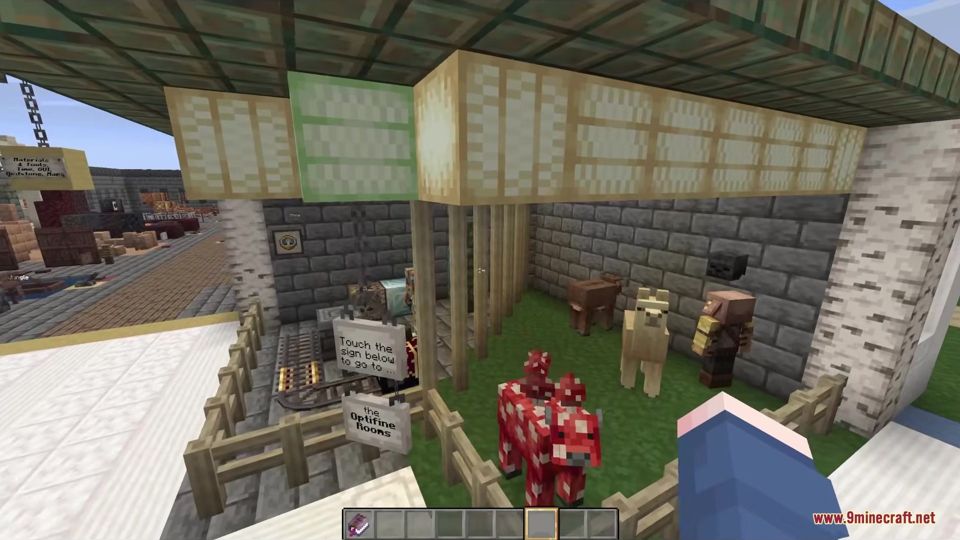 A fenced enclosure with various mobs and signs for different game rooms