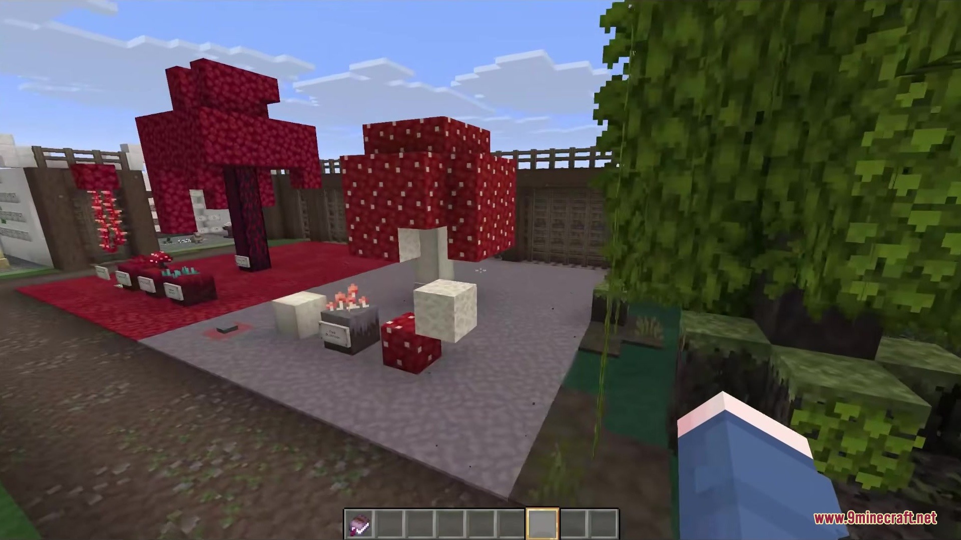 Giant red mushrooms and a fantasy tree in a stone courtyard area