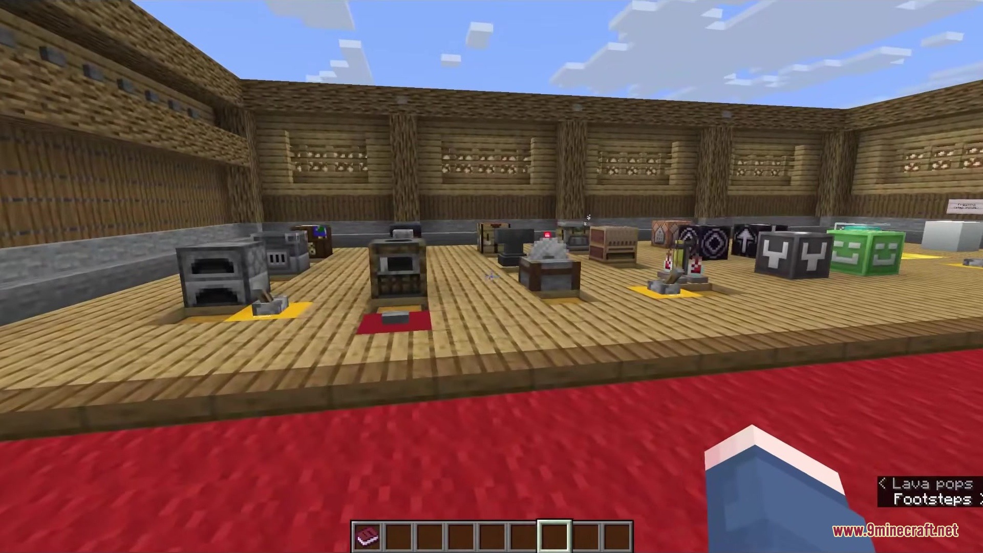 Various crafting stations and utility blocks are arranged inside a large wooden room