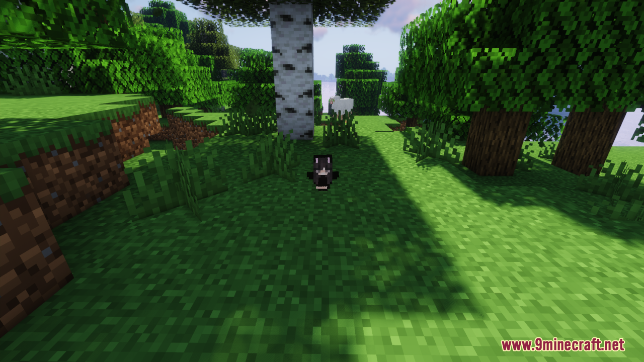 A small black character totem stands on the grass near a birch tree