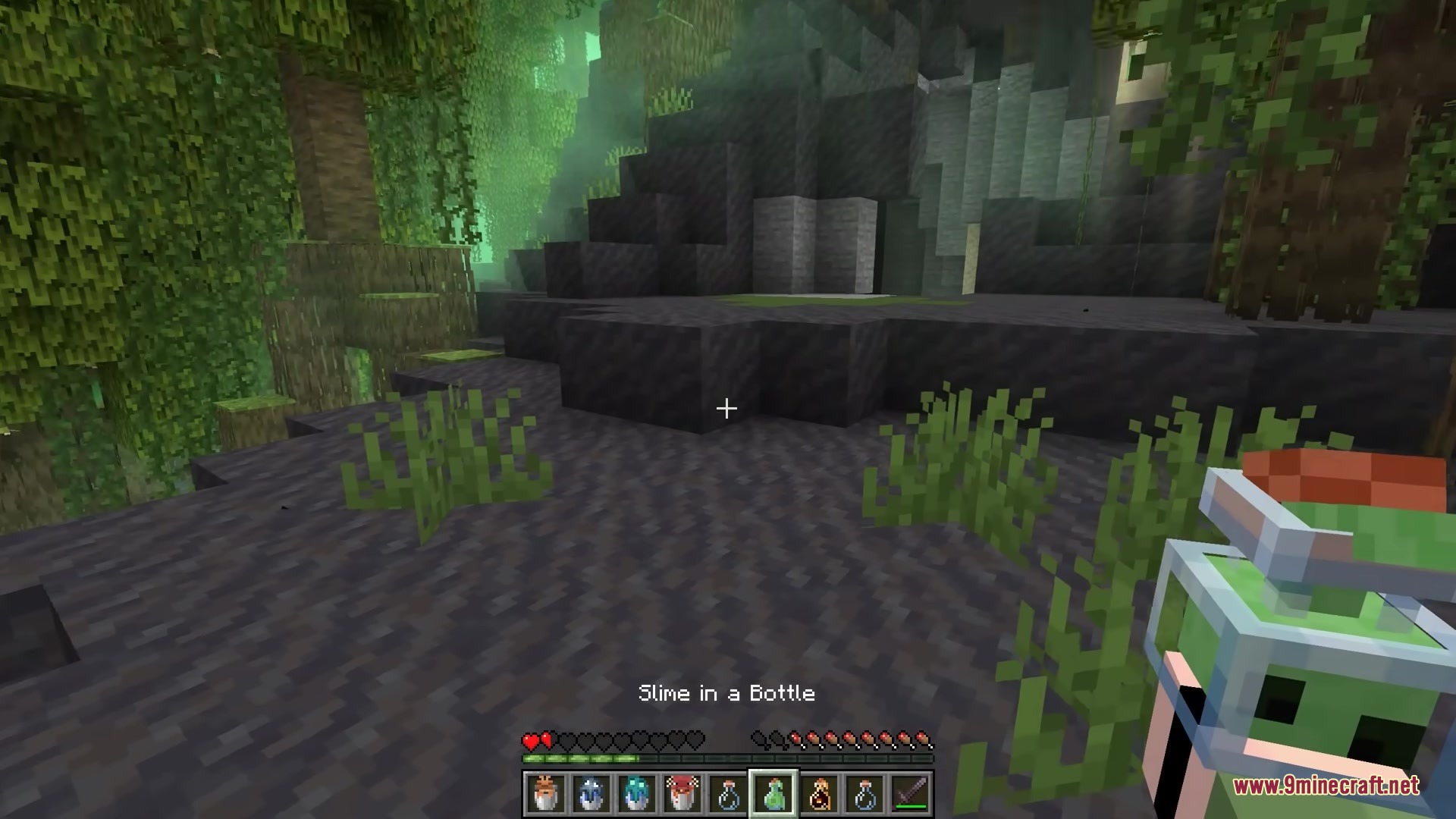 Bucket Em Remodeled Resource Pack Screenshot 2 The player holds a captured slime inside a detailed 3D glass bottle