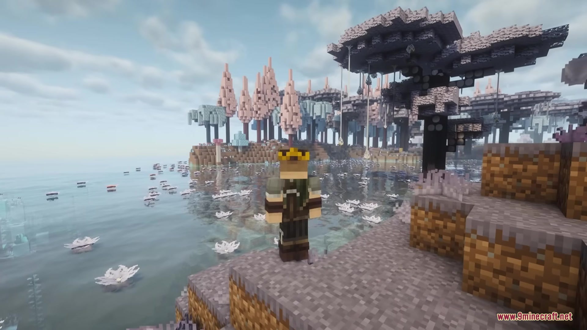 A player wearing a crown stands near a lake in a pastel forest