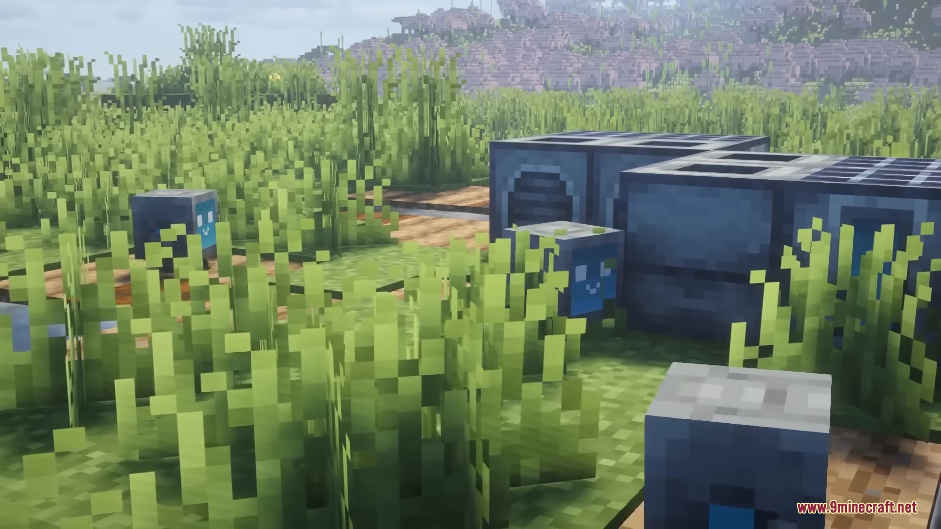 Blue Bytebuddies robots standing in tall grass near a docking station