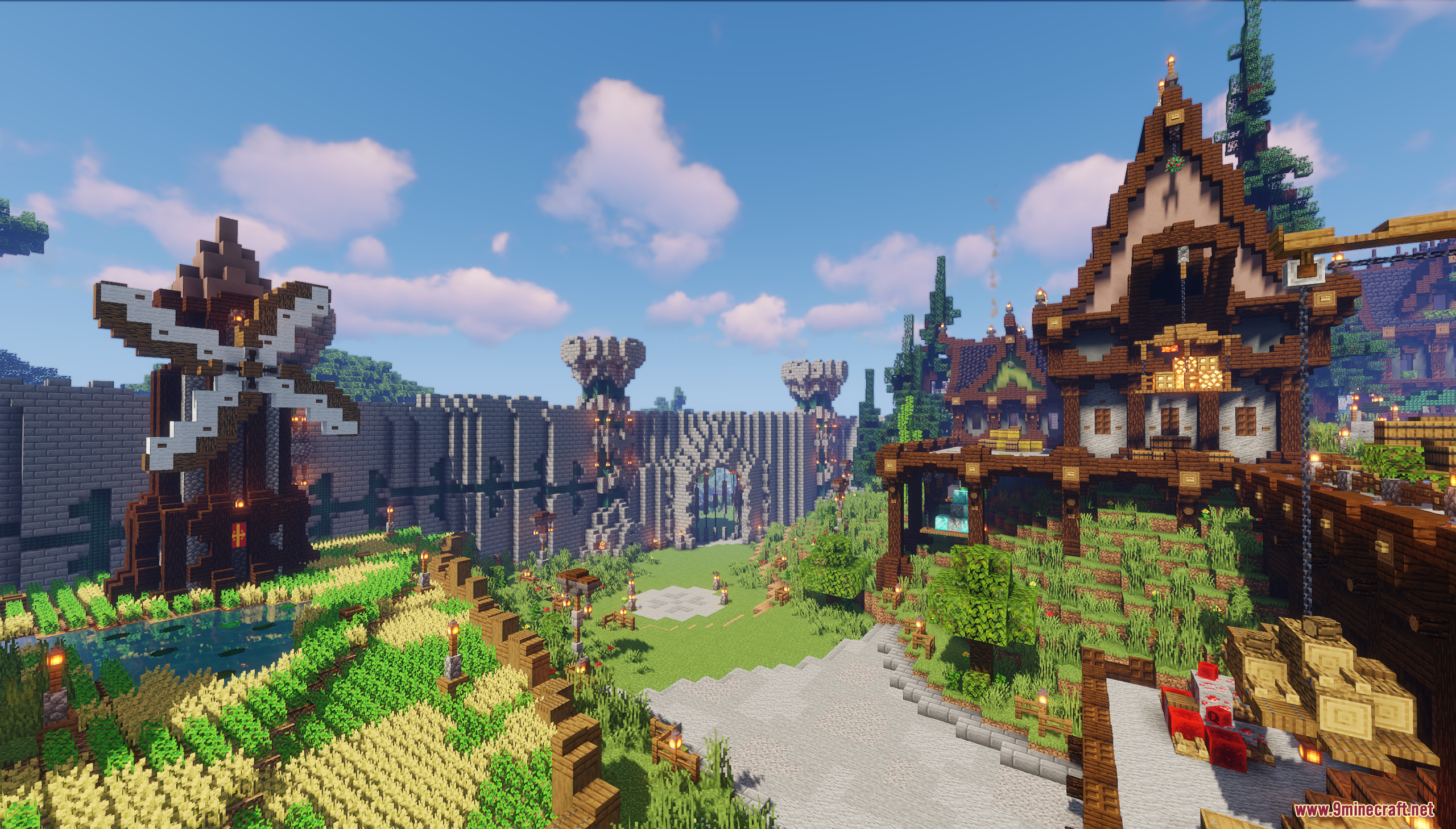 A windmill and wheat farm next to a massive stone castle gate