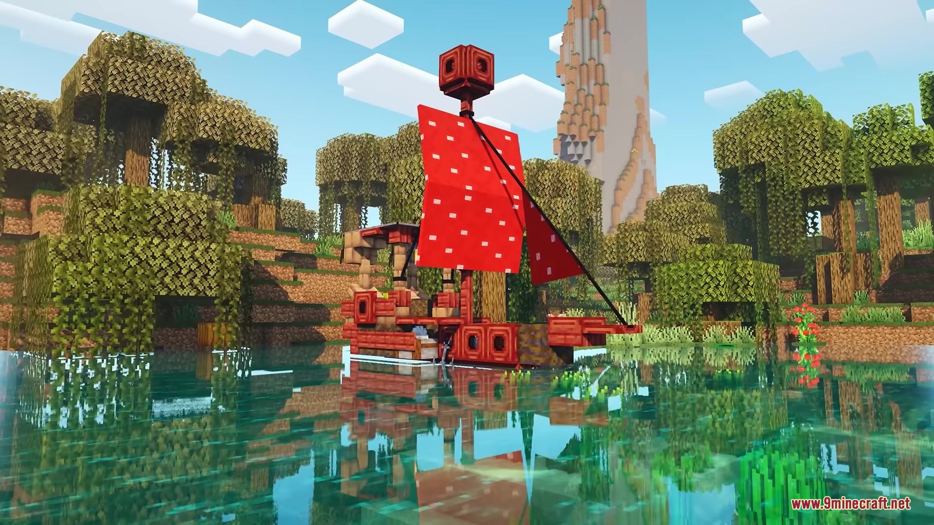 A red wooden ship with patterned sails floating in a mangrove swamp