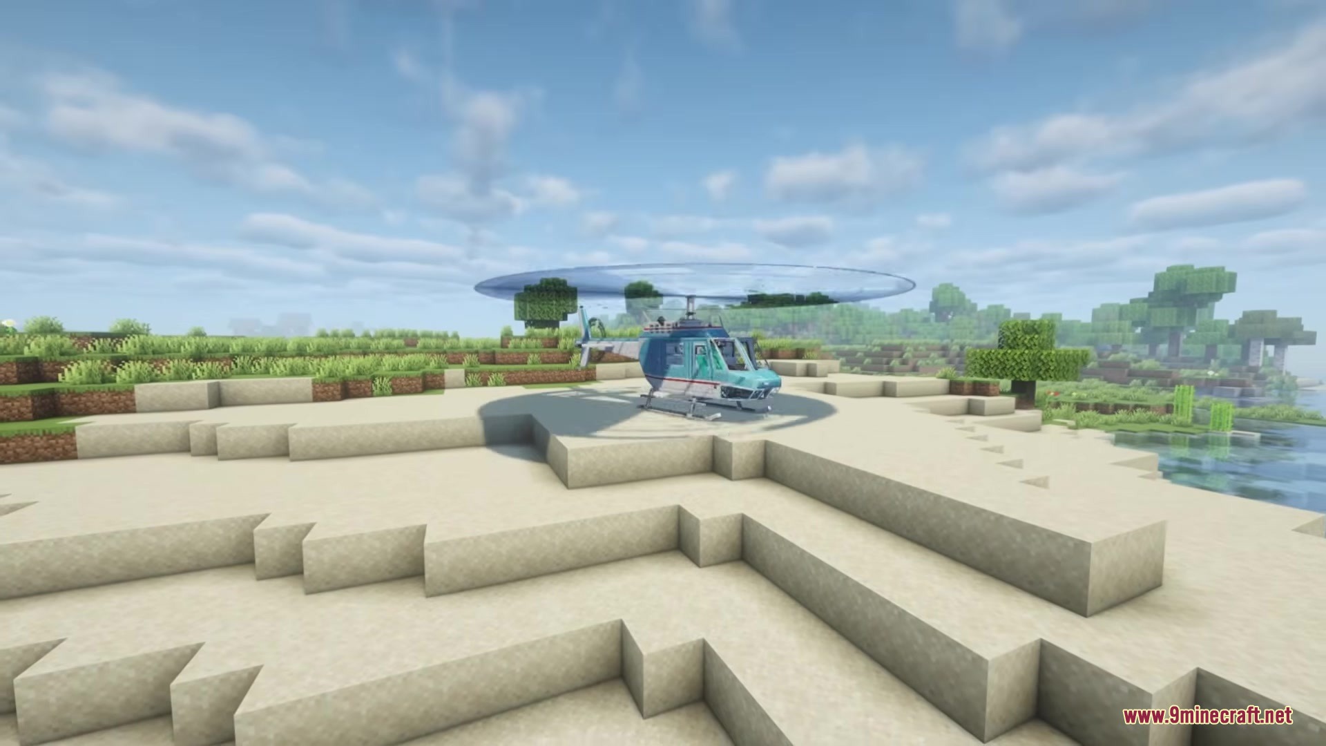 A blue and white Ranger Helicopter parked on a stone helipad near water