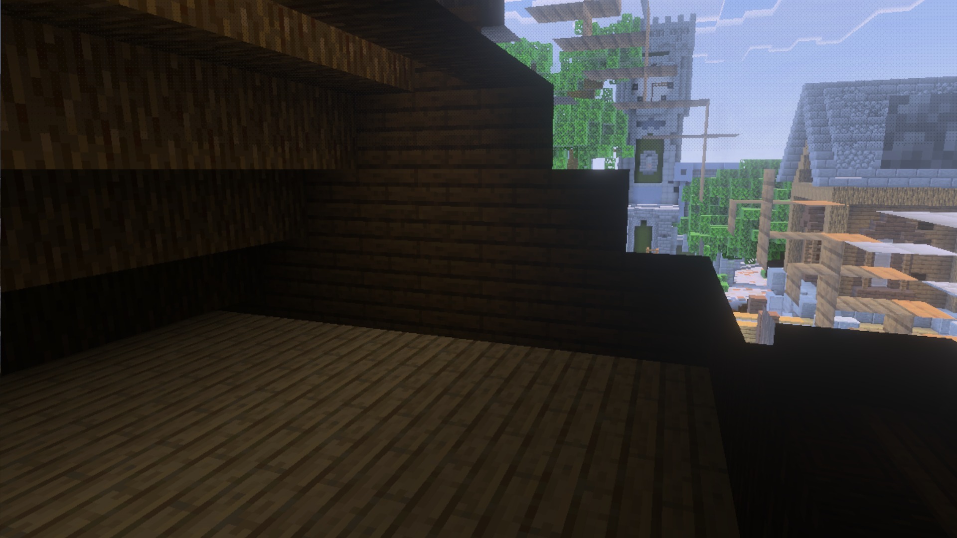 Interior view of a dark wooden room looking out at a stone tower