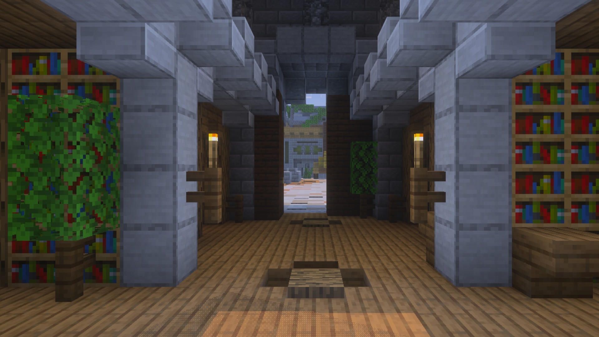 Interior view of a library hallway with wooden floors and stone pillars