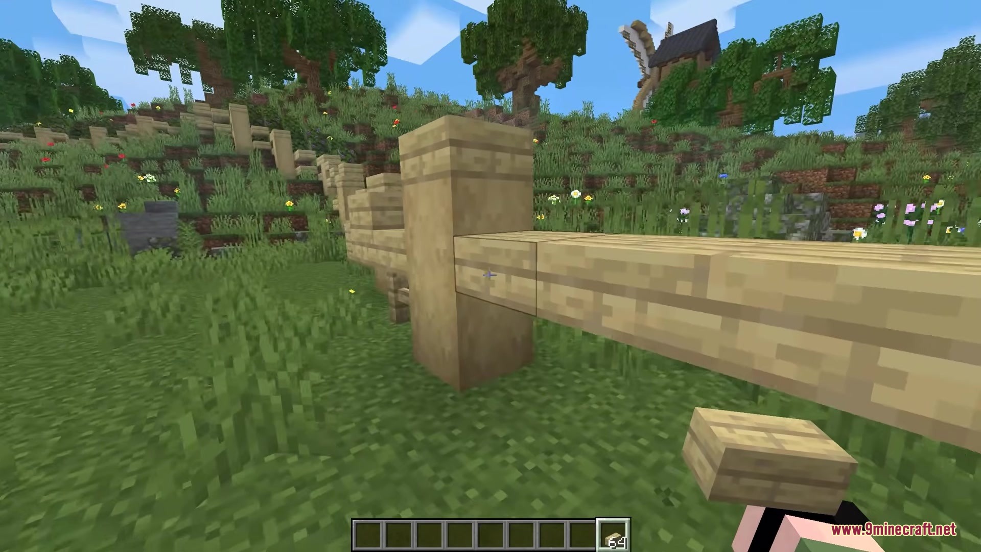 Player holding a wooden block next to a custom fence structure