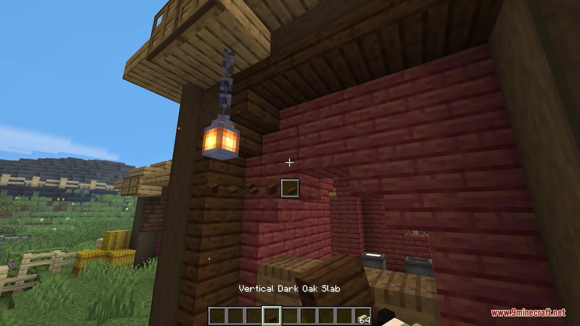 Player holding a vertical dark oak slab near a building with a lantern