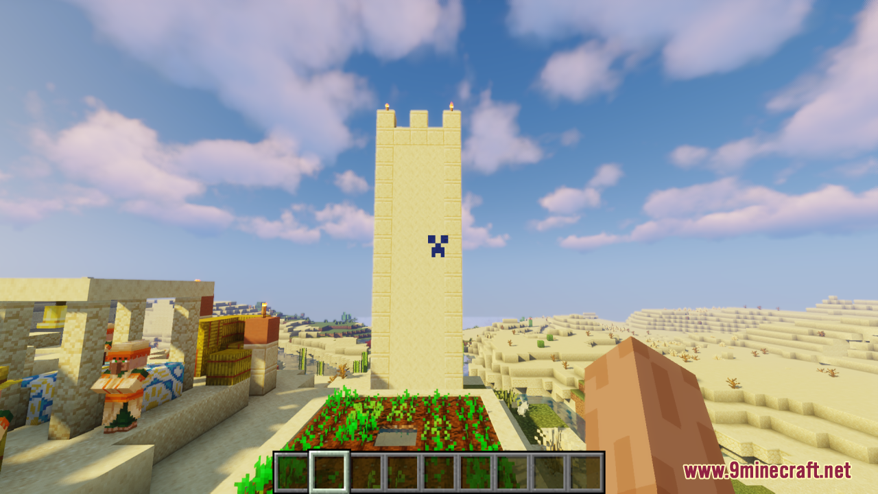 A tall sandstone tower in a village viewed through a Creeper crosshair