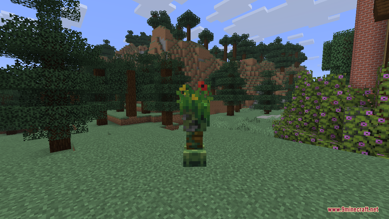 A close-up of the jungle creeper, its body wrapped in green leaves and dotted with small red and yellow flowers