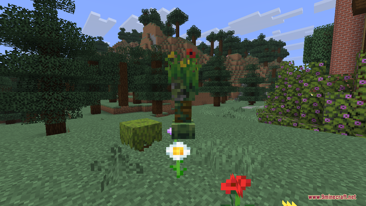 A leafy flowering creeper standing next to a mossy block, with a daisy and a poppy growing on the ground in front of it