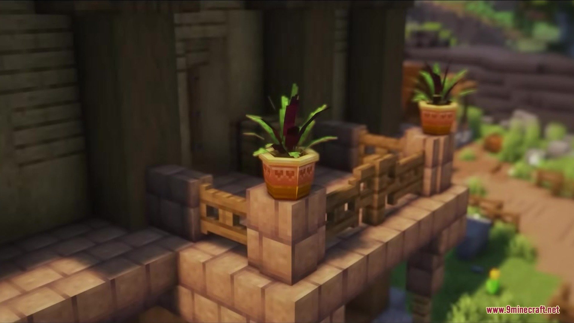 Decorative potted plants placed on the stone pillars of a wooden balcony railing
