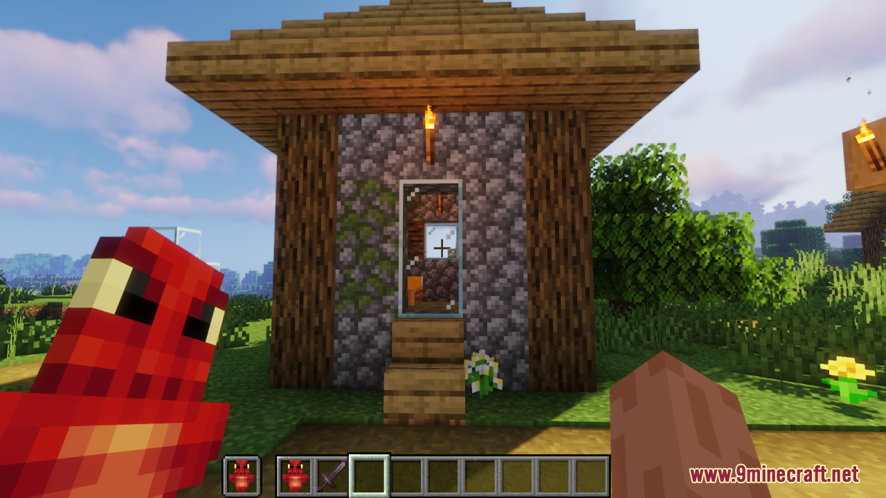 Dragon Totem of Undying Resource Pack Screenshot 11 Player holding a red dragon totem in front of a small cobblestone house