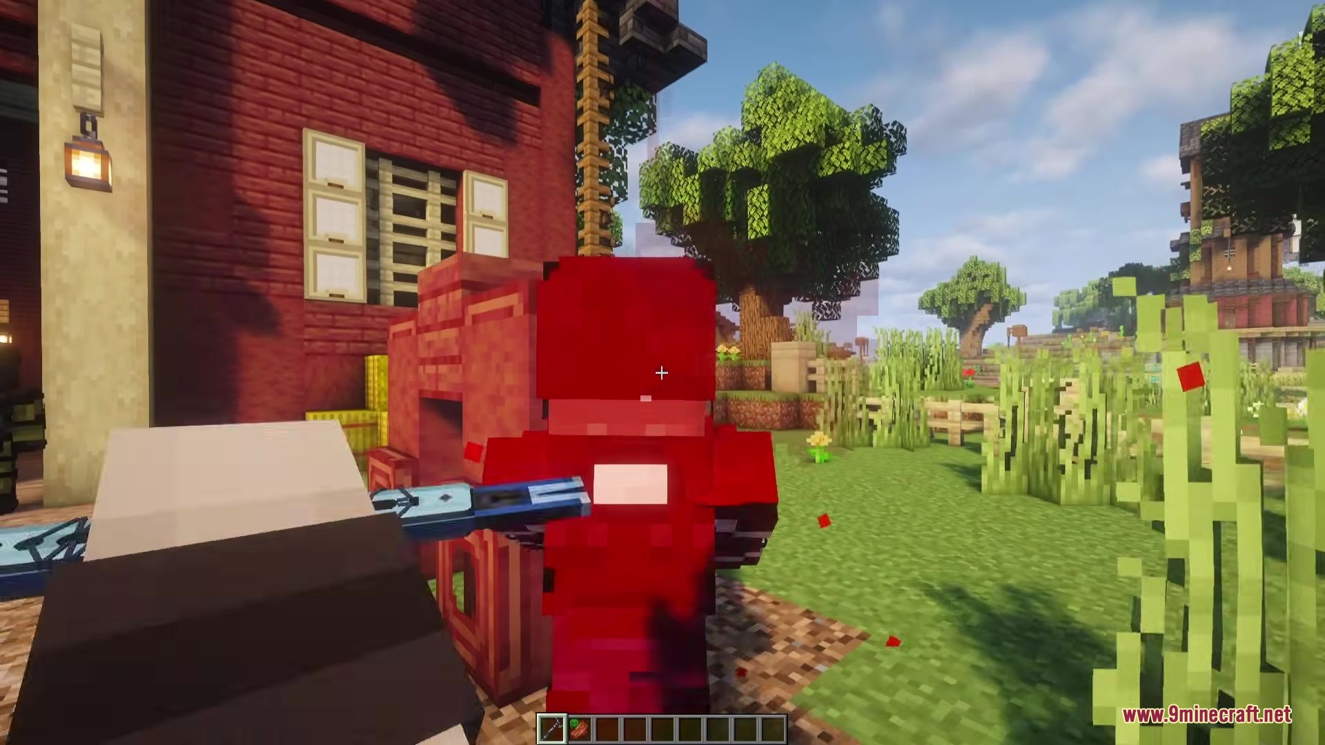 Player aims a blue weapon at a red flayed zombie near a building
