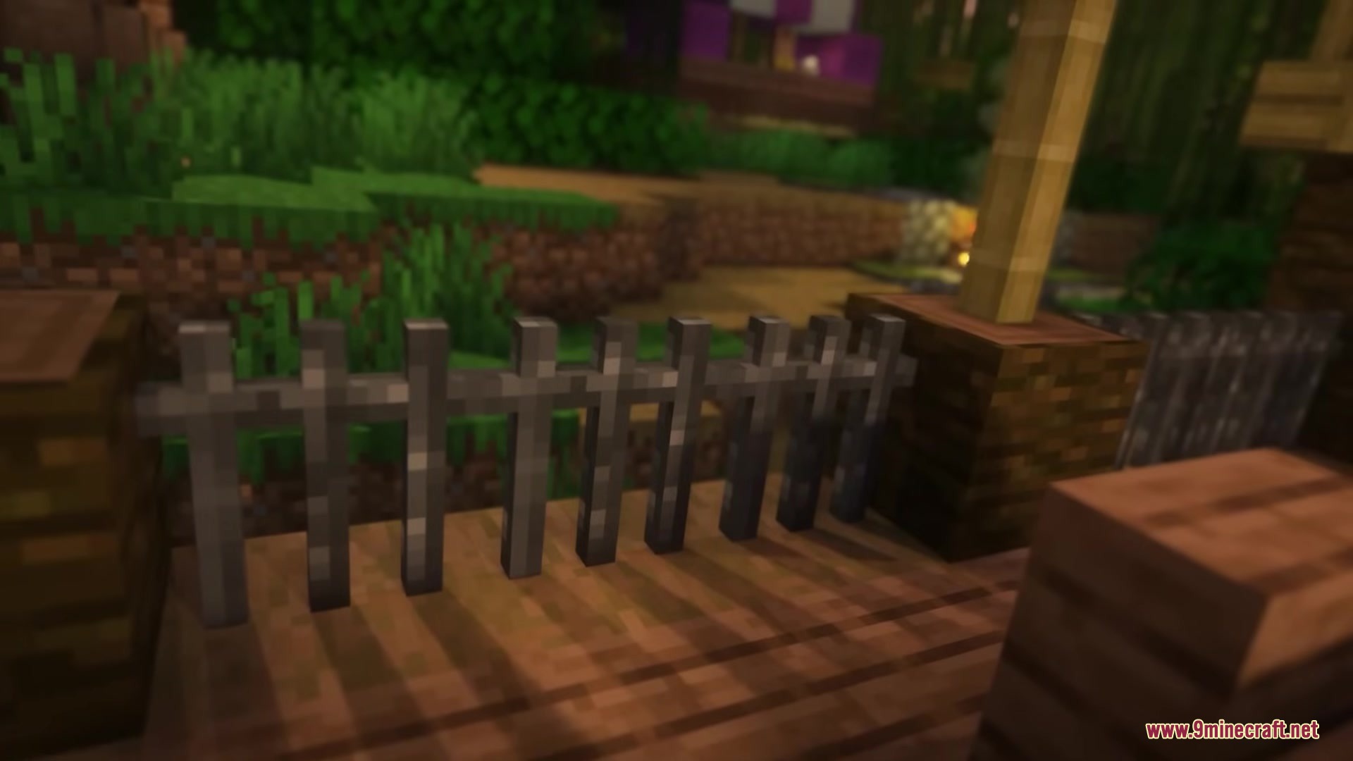 Enhanced Audio Ambience Sound Pack Resource Pack Screenshot 1 A dark wooden fence surrounded by lush green grass and trees